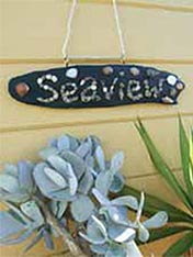 Transform driftwood into a unique and quirky house plaque
