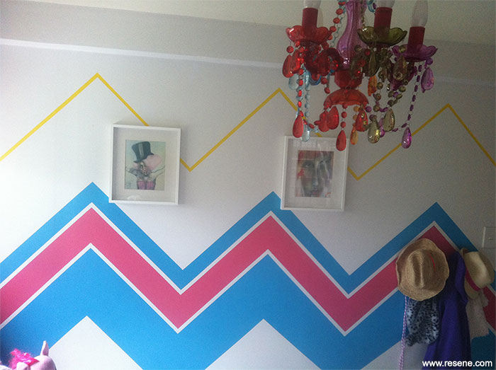 Feature wall in the bedroom - a chevron pattern using Resene Claret Resene Hullabaloo and Resene Turbo