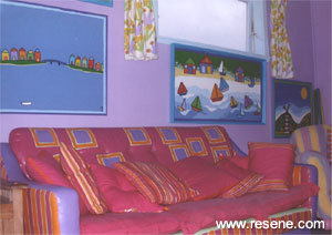 A couch is painted in Resene Cardinal with Resene Blue Gem and Resene Chilean Fire stripes and squares.