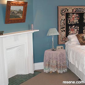 A guest bedroom painted with a vibrant Prussian blue