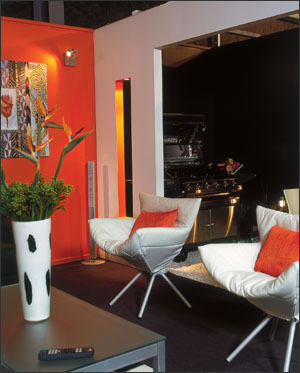A feature wall of Resene Fireball adds warmth and contrast to the predominantly black and white furnishings