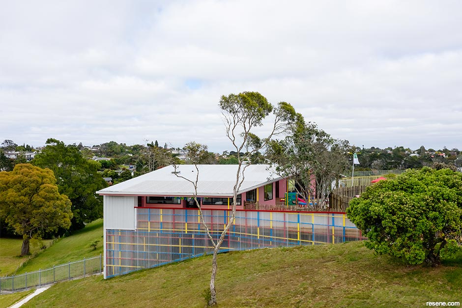 A pink school exterior with colourful fence