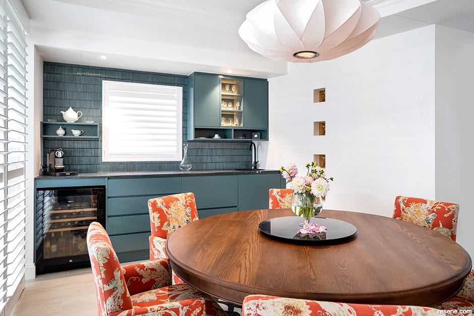 A deep blue green kitchen and dining room