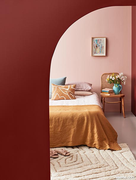 A red and pink bedroom with a curved wall
