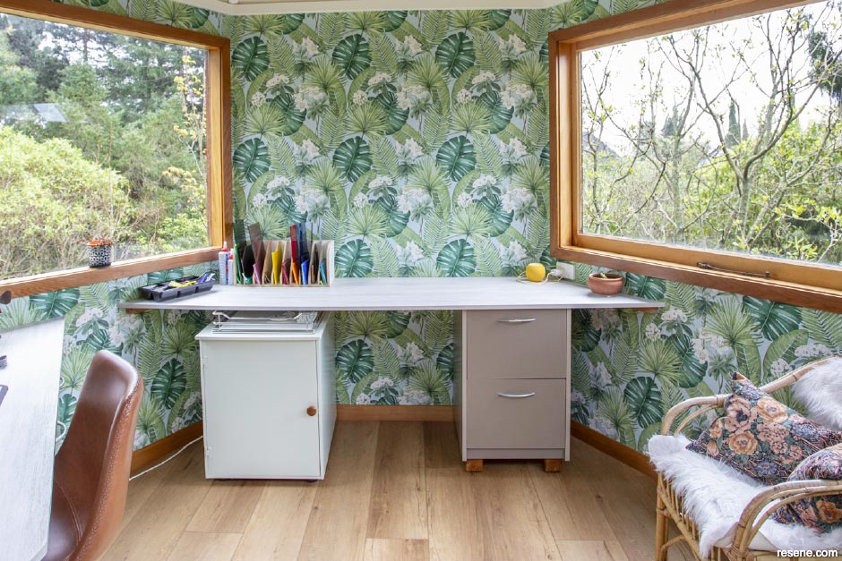 A home office with tropical wallpaper