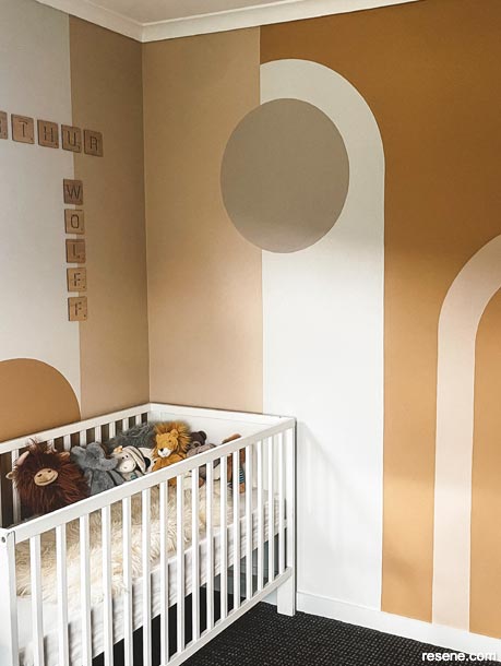 A honey toned nursery with wall mural