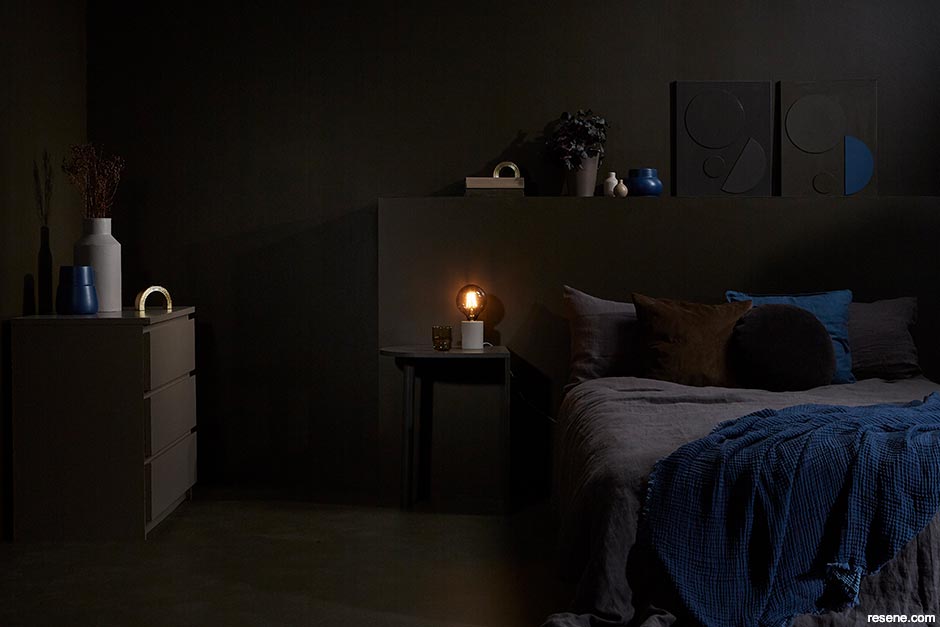 A dark brown bedroom with blue accessories