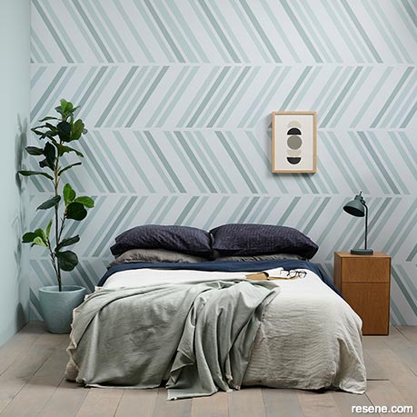 A bedroom with a painted herringbone design 