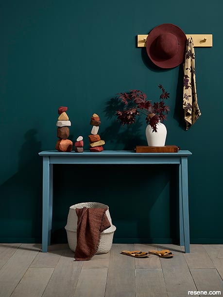 A green-blue hallway featuring accessories with earthy mineral tones