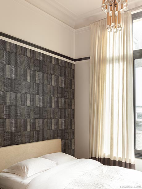 A bedroom with a textured wallpaper pattern