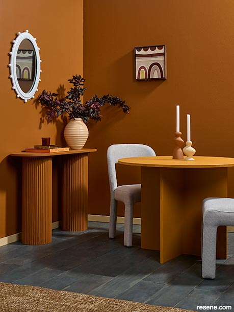 A minimalist dining room painted in earthy and spicy hues