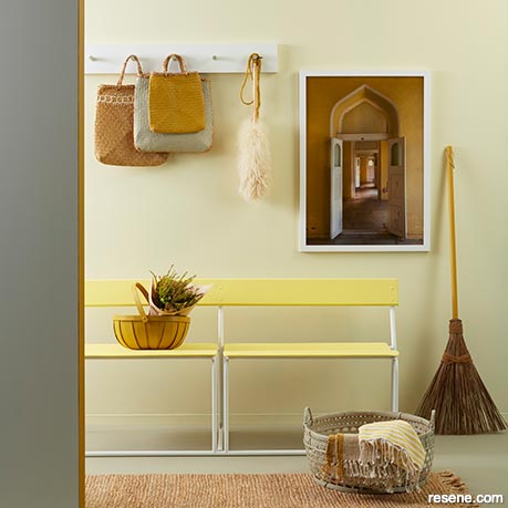 A mudroom with a soft yellow and neutral colour scheme