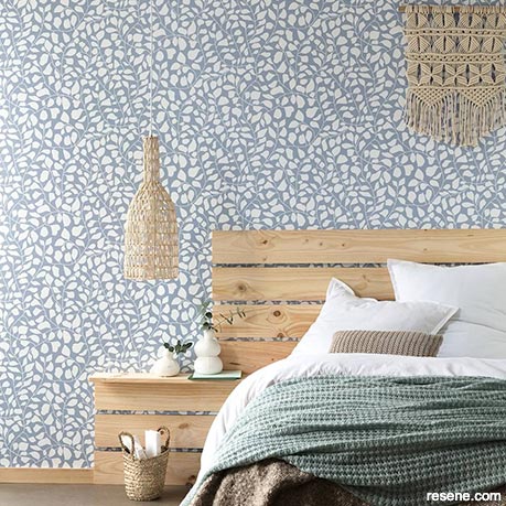 A bach bedroom with a nature-based wallpaper design
