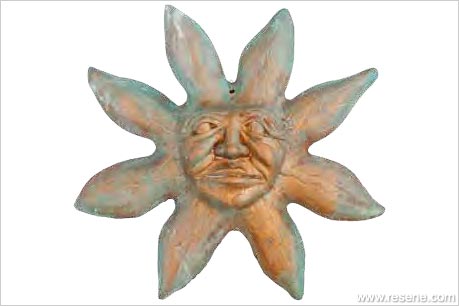 Terracotta sun face wall-hanging with verdigris paint effect