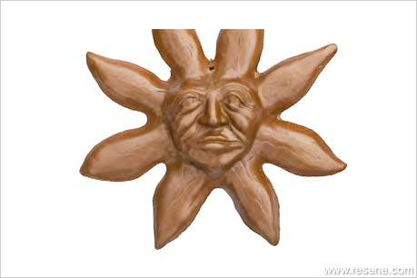 A terracotta sun face wall-hanging