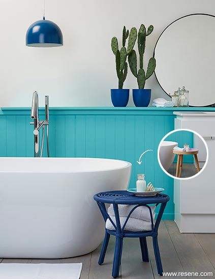 An aqua and white bathroom with tongue-and-groove panelling and shelf