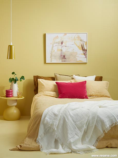A bright yellow bedroom with pink accessories
