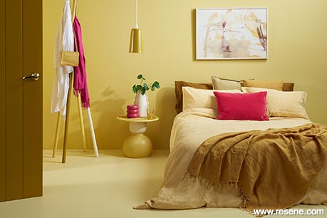 A sunny yellow bedroom with pink accessories