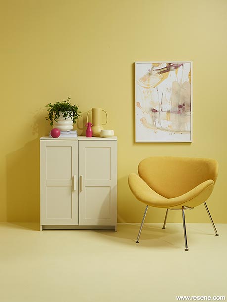 A yellow lounge with pink accessories
