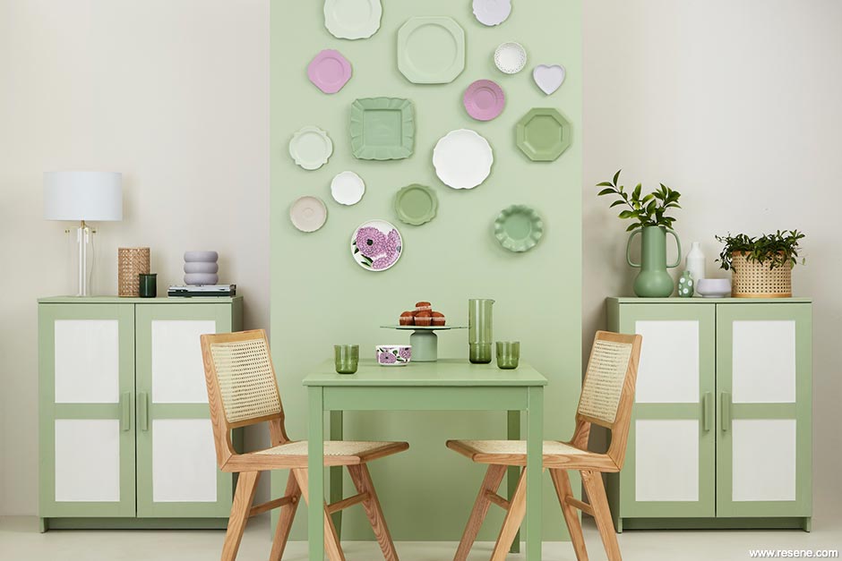 A light green dining room with painted wall plates