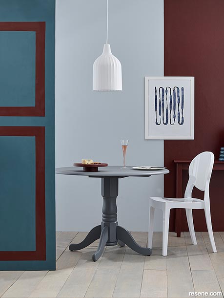 A dining room with burgundy and blue feature wall