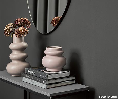 A dark moody lounge with pink vases