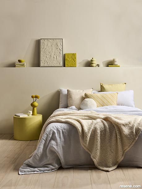 A neutral bedroom with bright yellow accessories
