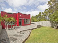 A 1930s stucco home is painted Resene Pohutukawa red
