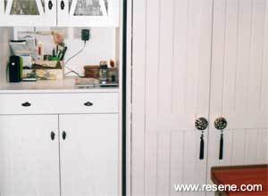 A small kitchen is repainted with Resene Nero cabinets as a foil for Resene Sandacastle and Resene Pixie Dust walls