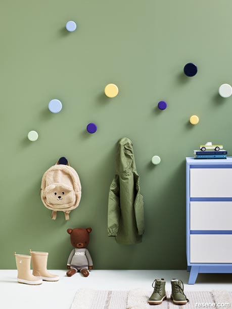 A green kids' room with painted wall hooks