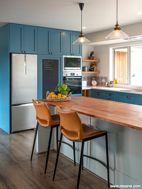 A blue and green kitchen with island