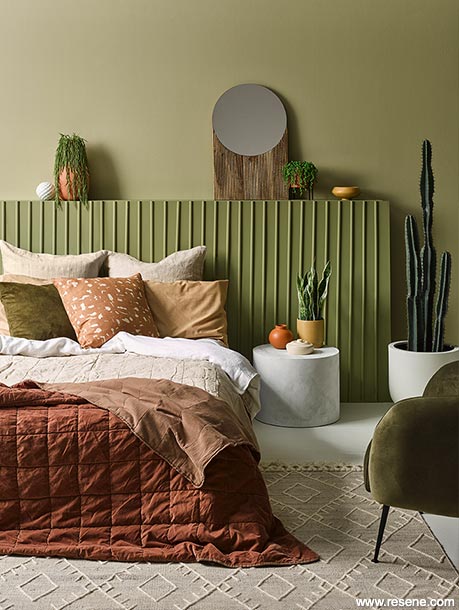 An earth-toned bedrom in olive green and terracotta