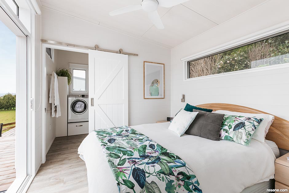 An airy tiny home bedroom painted in Resene White Pointer