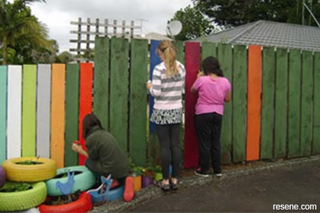 Use leftover paint to create a colourful fence
