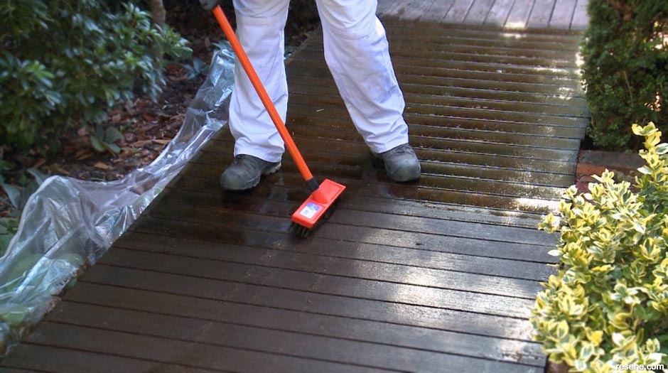 Scubbing the timber deck with a short-bristled brush