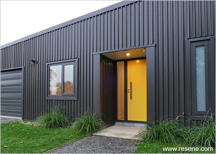 Corrugated exterior in dark colours with yellow door